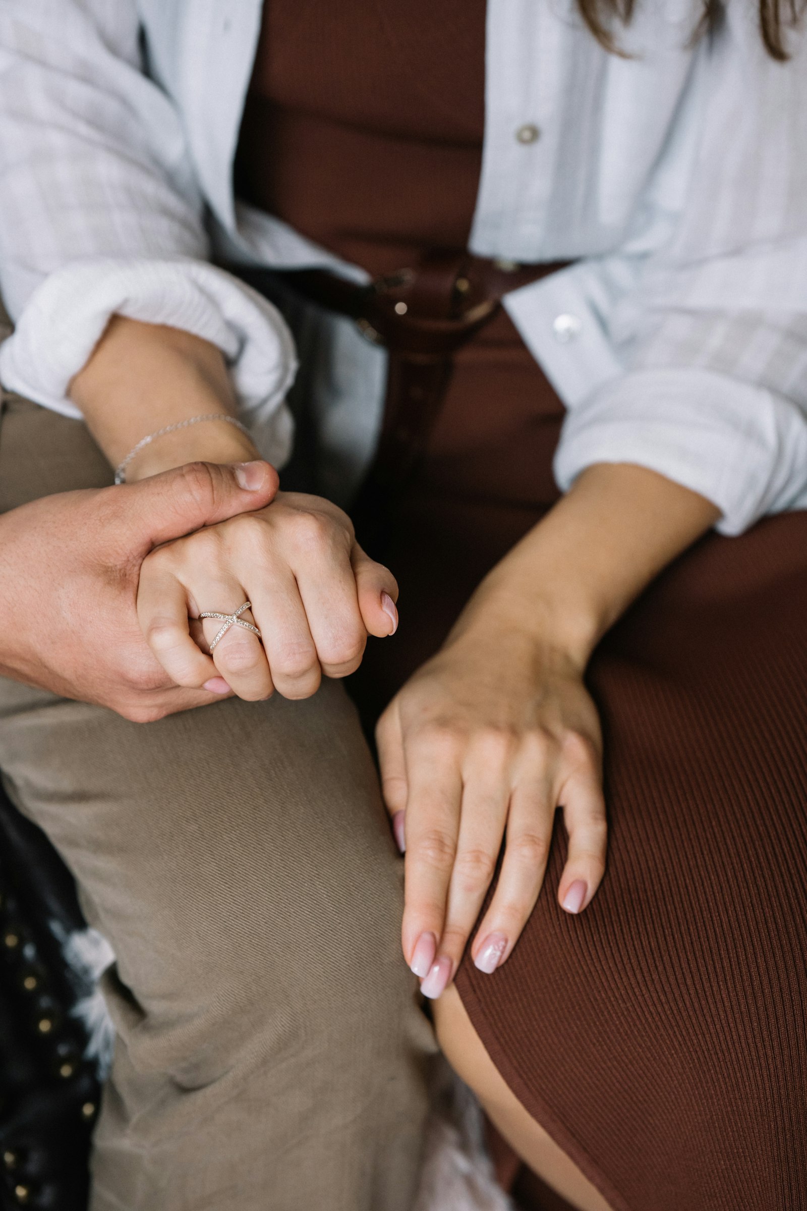 Two partners holding hands while sitting close together