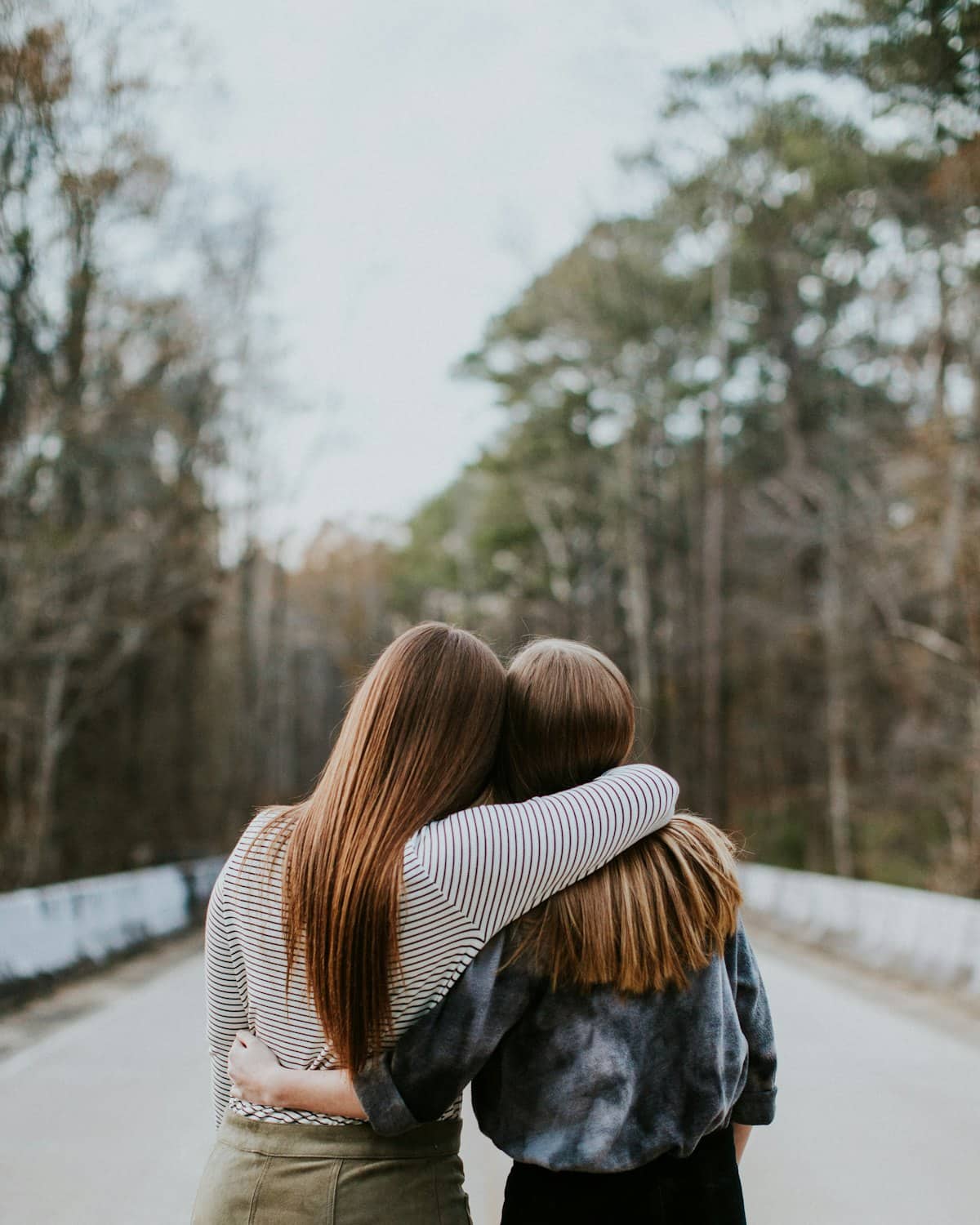 Two people sharing a supportive hug outdoors
