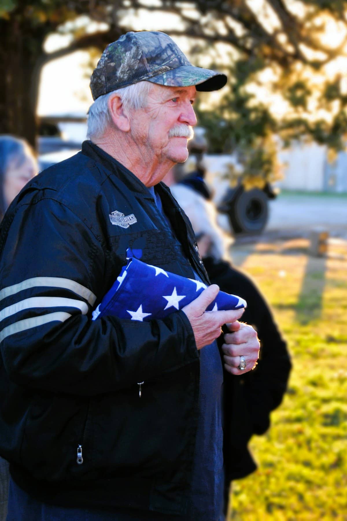 A Veteran holding a folded American flag
